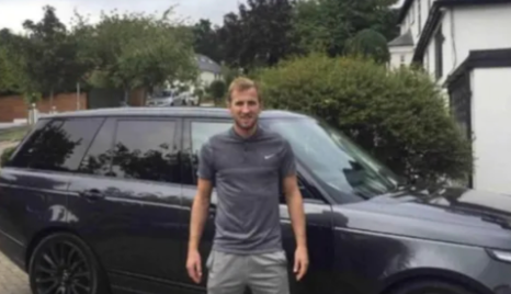 Harry Kane posing for a photo with car