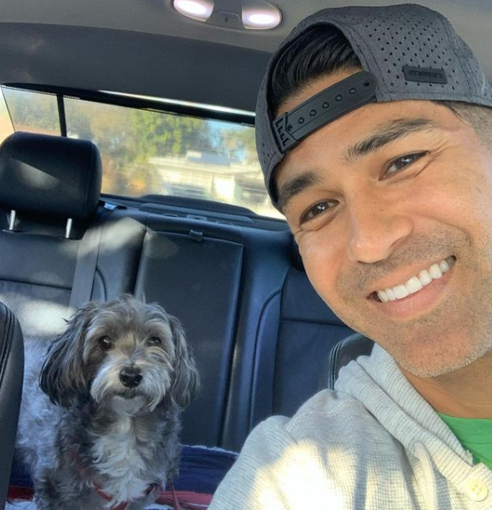 Craig Melton sitting inside the car and clicking selfie with his dog