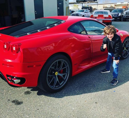 Luke Roessler posing for a photo with car