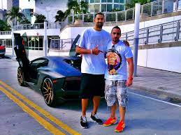 Juwan Howard posing for a photo with his car
