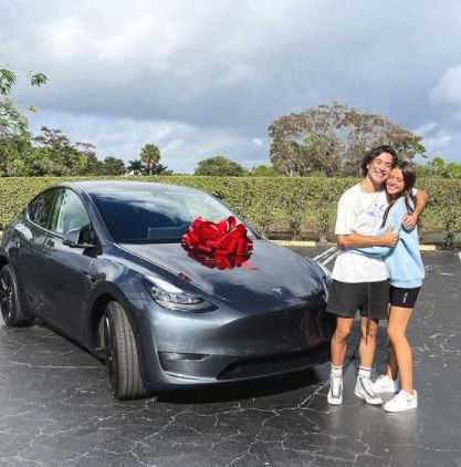 Gabriel Conte and his wife, Jessica posing with their car