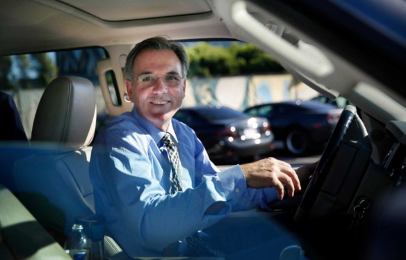 Tara Beane's husband, Billy Beane posing inside his car