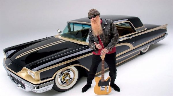 Late Dusty Hill posing for a photo with a car