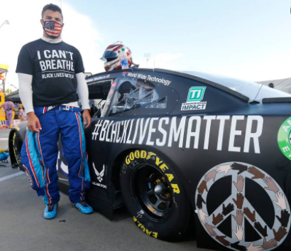 Bubba Wallace posing for a photo with car