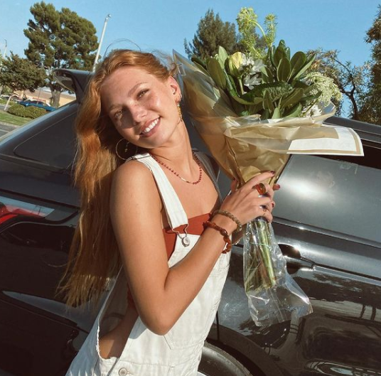 Nadia Turner posing for a photo with a car 