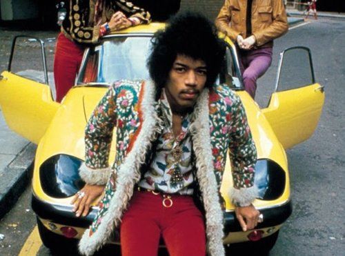Late Jimi Hendrix posing for a photo with his car