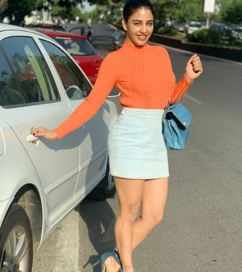 Daksha Nagarkar posing for a photo with her car