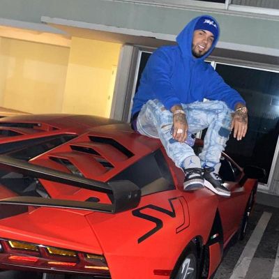 Anuel AA posing with his car