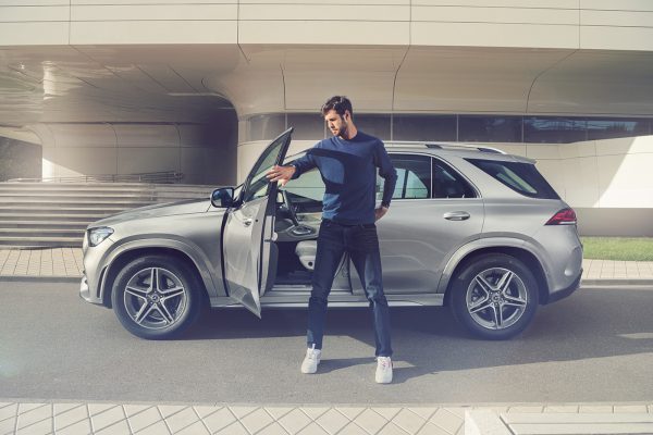 Karen Khachanov posing for a photo with his car