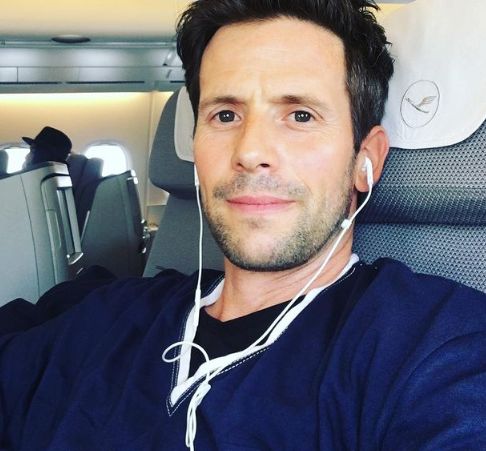 Christian Oliver posing inside a plane