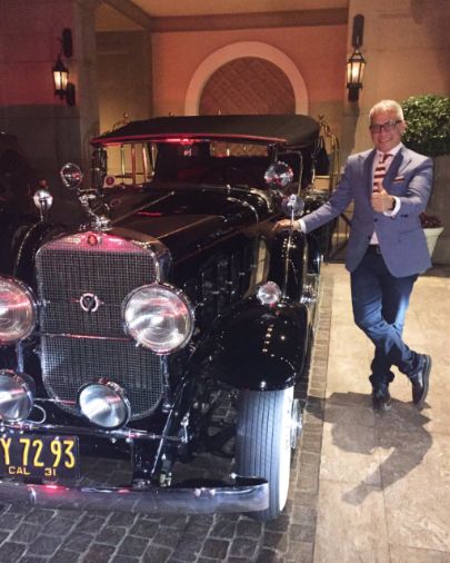 Geoffrey Zakarian posing with his car