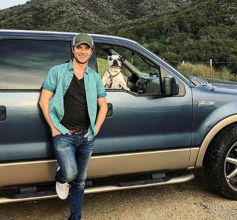 Jeremy Sumpter posing with his car