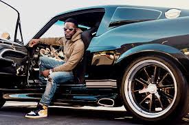 Kevin Hart posing for a photo with car