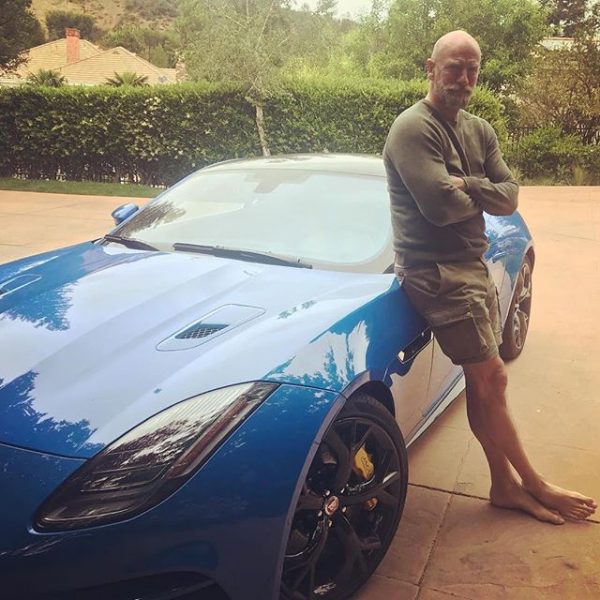 Graham McTavish posing for a photo with his car 