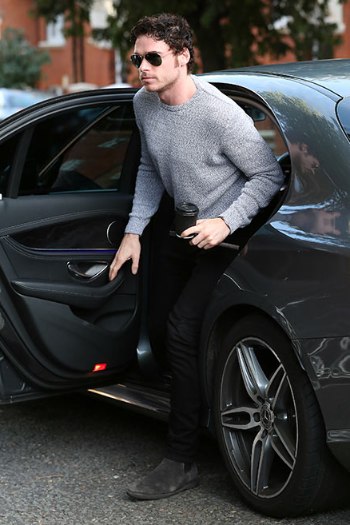 Richard Madden posing with his car