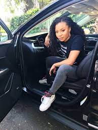 Shalita Grant posing for a photo with her car