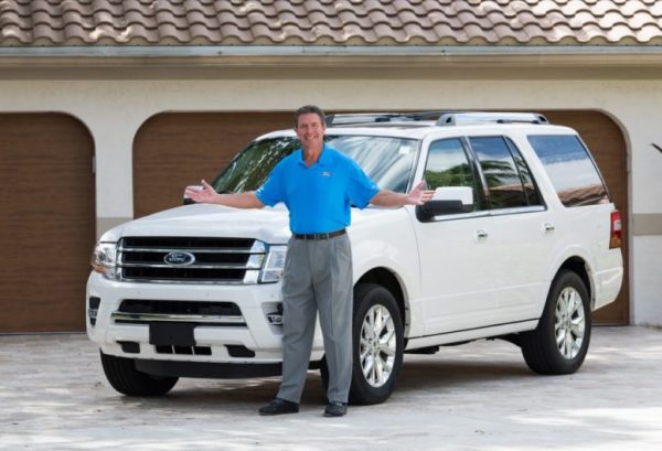 Dan Marino posing for a photo with his car