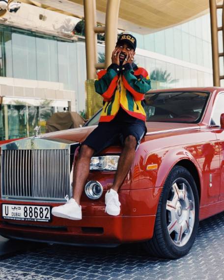 Big Sean posing with his car