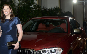Maggie Carey posing for a photo with her car 