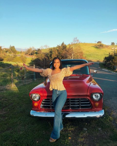 Asia Ray posing for a photo with her car