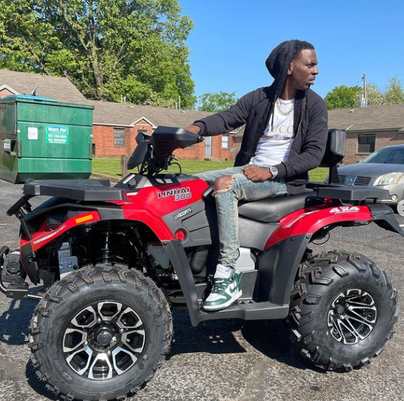 Young Dolph posing for a photo with his bike