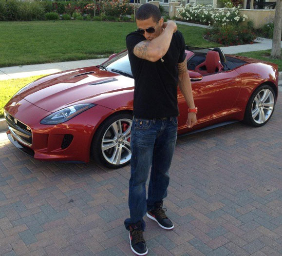 Colin Kaepernick posing for a photo with his car