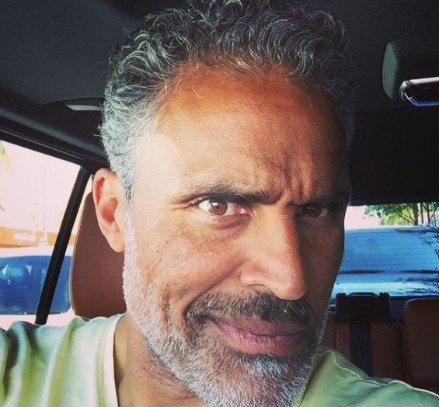 Rick Fox posing inside his car