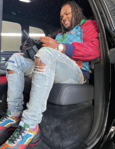 Tee Grizzley posing inside his car