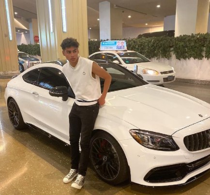 Andrew Davila posing with his car