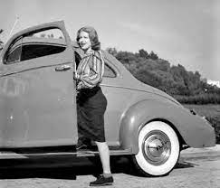 Lahna Turner posing for a photo with her car