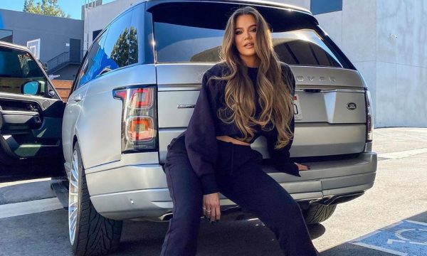 Kim Kardashian posing for a photo with her car 