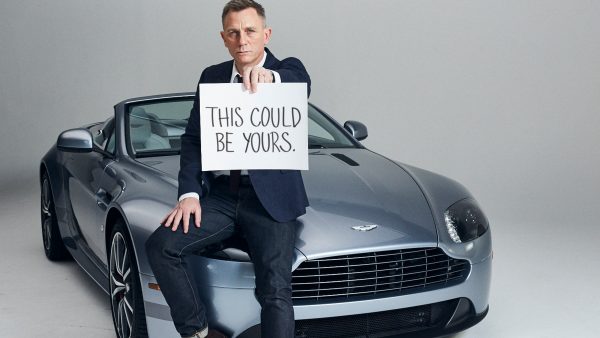 Daniel Craig posing for a photo with his car 