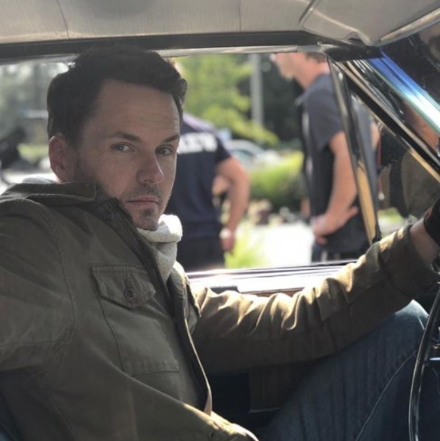Paul Campbell posing inside his car