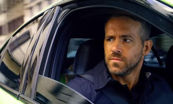 Ryan Reynolds posing from his car