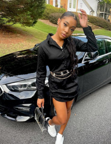 Mya Nicole Johnson posing for a photo with her car 