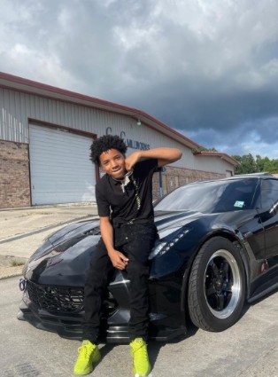Bad Kid Mykel posing for a photo with his car