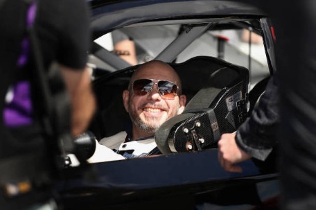 Pitbull sitting inside his car