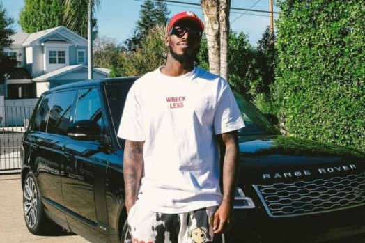 Pardison Fontaine posing for a photo with his car
