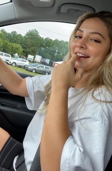 Pam Cline's daughter, Madelyn Cline posing inside her car