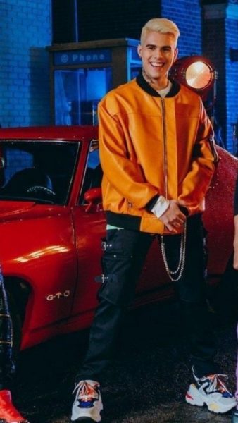 Zabdiel De Jesús posing for a photo with his car