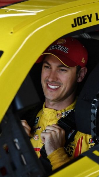 Joey Logano sitting side his car