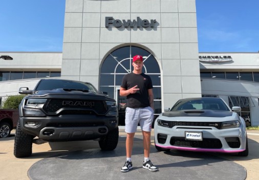Spencer Rattler posing for a photo with his car