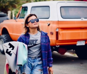 Sky Brown posing for a photo with her car