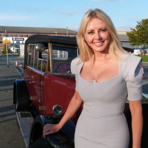 Cameron King's mother, Carol Vorderman posing with car