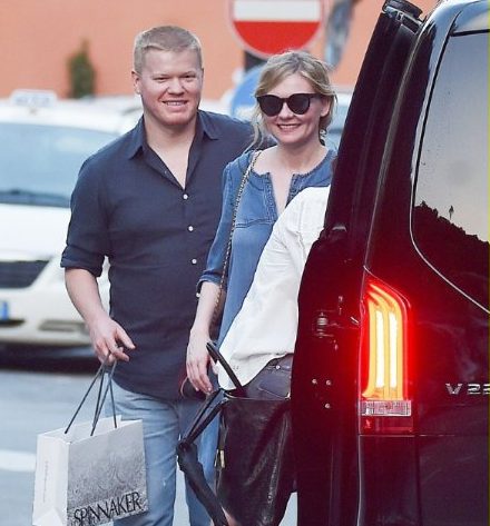 Jesse Plemons posing in front of a car with his Fiancee 