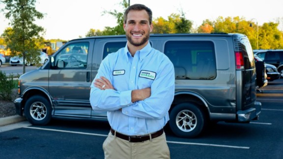 Kirk Cousins posing for a phpto with his car