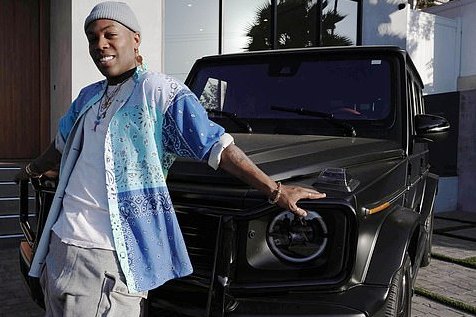 Todrick Hall posing in front of the car