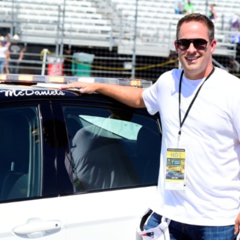 Laura McDaniels's husbnad posing in front of a car