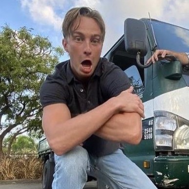 Drew Starkey posing with car