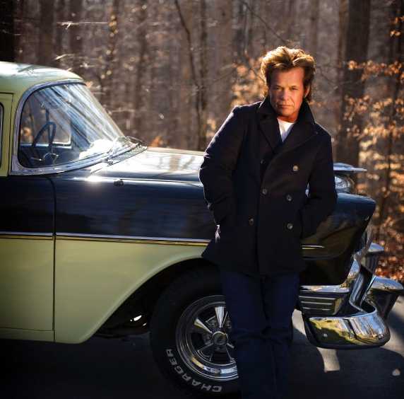 John Mellencamp posing infront of his car